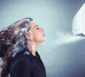 Frau mit gefrorenen Haaren vor einer Klimaanlage