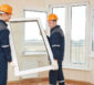 Zwei männliche Handwerker installieren ein Fenster.
