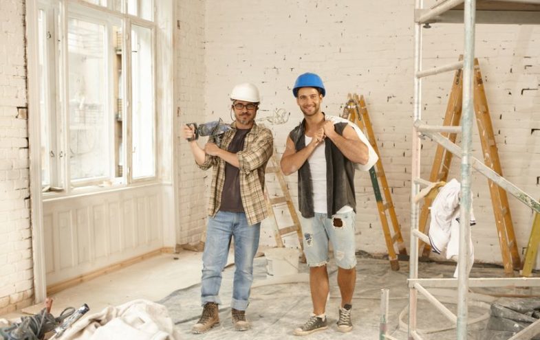 Zwei männliche Handwerker bei der Innenraumrenovierung.