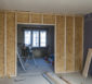 Trennwand aus Holzplanken und Spanplatten im Innenraum eines Wohnhauses.