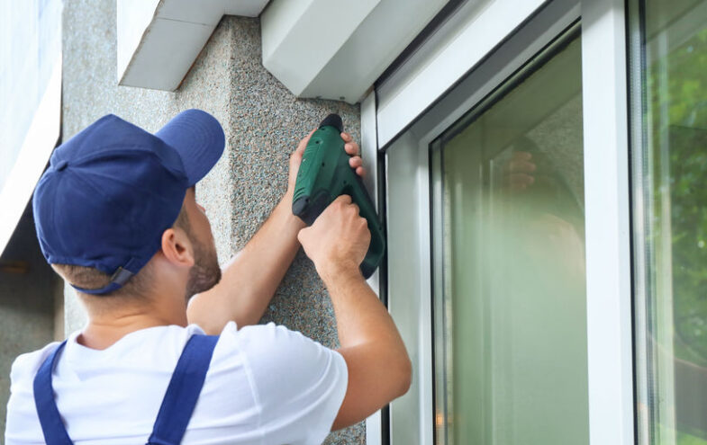 Männlicher Handwerker installiert einen Storenkasten von aussen.