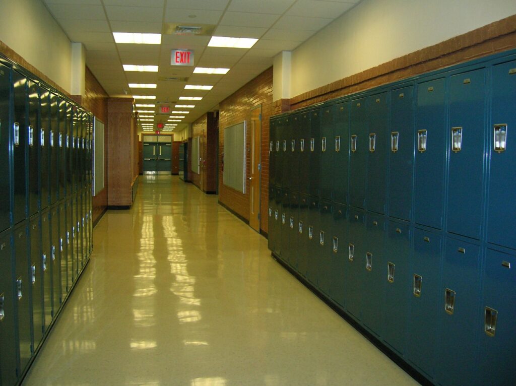 Flur einer Schule mit blauen Schliessfächern auf beiden Seiten.